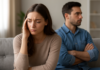 When Your Partner Cannot Give You the Love You Need Two adults sitting apart on a sofa, one holding her forehead and the other folding his arms.