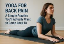 Yoga for Back Pain: A Simple Practice You’ll Actually Want to Come Back To Woman practicing a gentle Sphinx yoga pose on a mat in a bright room for back pain relief