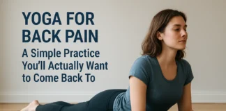 Yoga for Back Pain: A Simple Practice You’ll Actually Want to Come Back To Woman practicing a gentle Sphinx yoga pose on a mat in a bright room for back pain relief