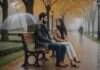Betrayal in Relationships: The Signs Trust Can Be Rebuilt Without Pretending Nothing Happened Two adults talking on a park bench beneath an umbrella on a rainy autumn day.