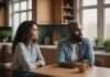 What Communication Can Repair After Infidelity and What Cannot Two adults sitting at a kitchen table and looking in the same direction.