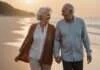 How Do Successful Couples Stay Together? The Signs to Look For Before You Make Your Next Move Two older adults smiling together while walking hand in hand along a beach at sunset.