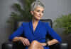 When a Promotion Comes With More Responsibility but No Real Raise Woman with short gray hair sitting in an armchair in a bright office.