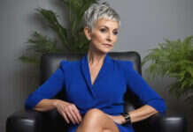 When a Promotion Comes With More Responsibility but No Real Raise Woman with short gray hair sitting in an armchair in a bright office.