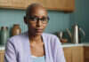 Divine Feminine Path to the Love You Deserve | Bella Kent Woman in a purple blouse in a bright kitchen.