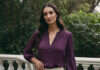 How I Became Irresistible to the Kind of Man I Once Begged to Stay A woman in a purple blouse pausing on a garden terrace.