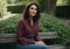 Why Happiness Alone Brings Guilt in a Long-Term Relationship A woman with dark waves enjoying a quiet moment on a garden bench.