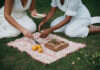 Date Night Ideas for Couples: Creative Ideas That Make Quality Time Feel Fun Again Two adults enjoying a picnic activity with food and a wooden game board.