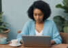 AI Dating Advice: What Actually Helps When Modern Dating Feels Exhausting Woman sitting beside a laptop with its plain back facing the camera.