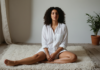 When Wellness Practices Fail to Help You Feel at Home in Your Body A woman practicing a gentle grounding pause in a comfortable room.