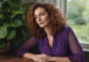 Ghosting: The Internet Made It Viral. Here’s What It Means in Real Relationships Woman with auburn curls and a purple blouse resting beside a leafy window.
