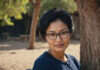 Relationship Deal Breakers: How to Tell What Really Matters Before Chemistry Makes the Decision for You A woman with glasses sitting thoughtfully beside a tree.