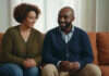 Improving Intimacy: How to Rebuild Closeness When the Spark Feels Far Away Two partners sharing a relaxed moment on a sofa.