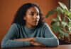 Relationship Burnout: What to Notice Before the Pattern Becomes the Relationship A woman taking a thoughtful pause at a table.
